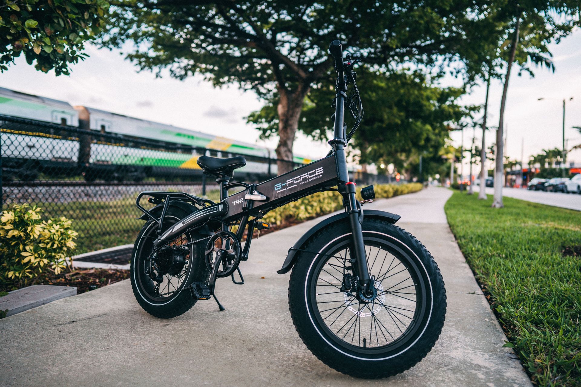 Compact foldable electric bike parked on an urban sidewalk, showcasing modern transportation.